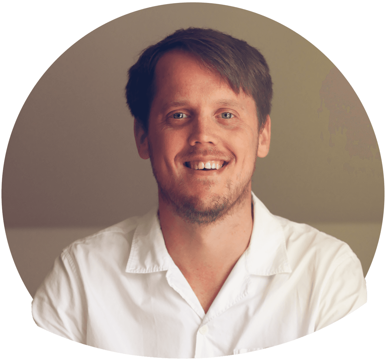 Tommy smilende med smilehuller i hvid kortærmet skjorte. Foto.