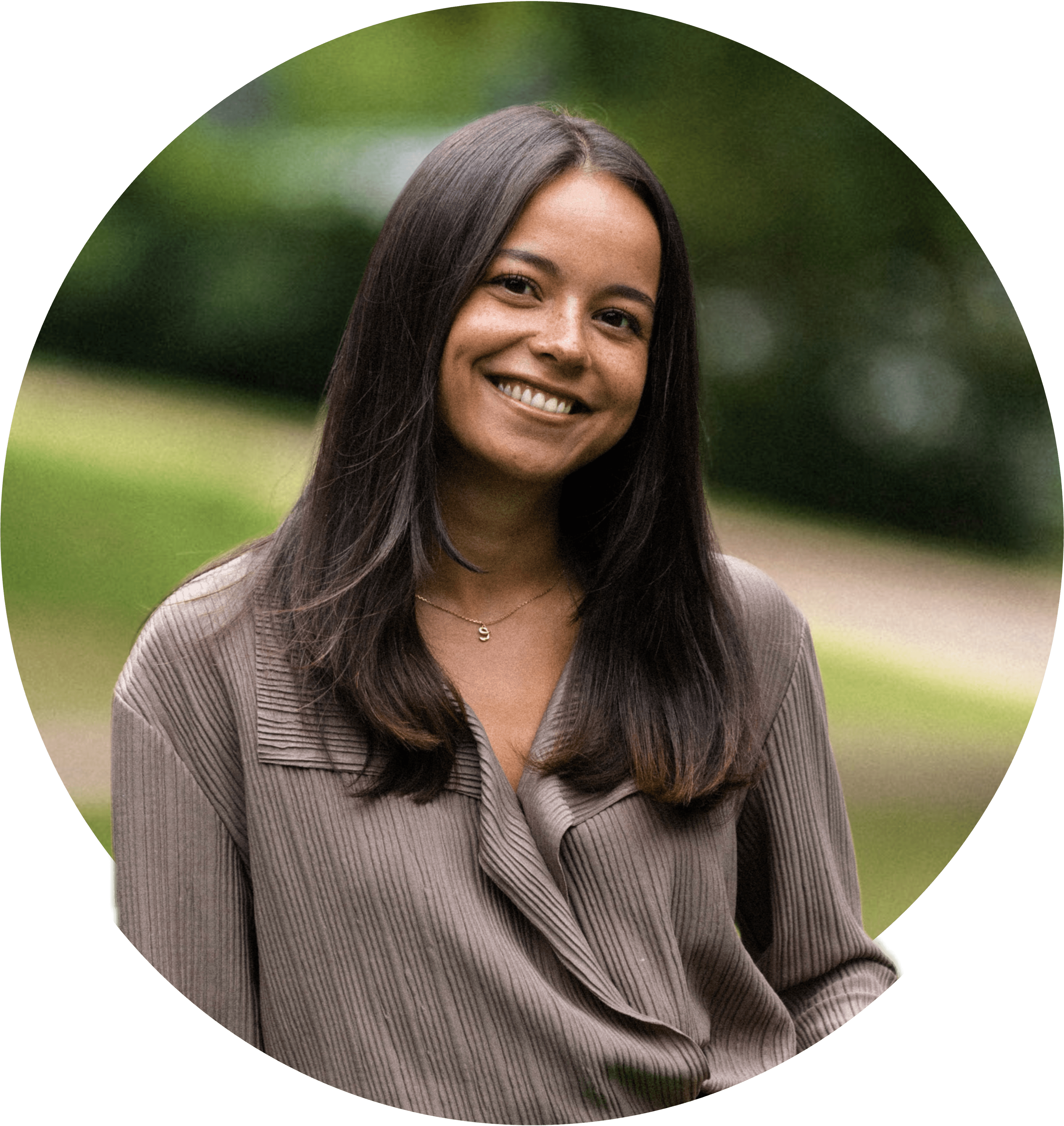 Elsa smiler bredt, iført en lysebrun bluse, med mellemlangt brunt hår. Foto.